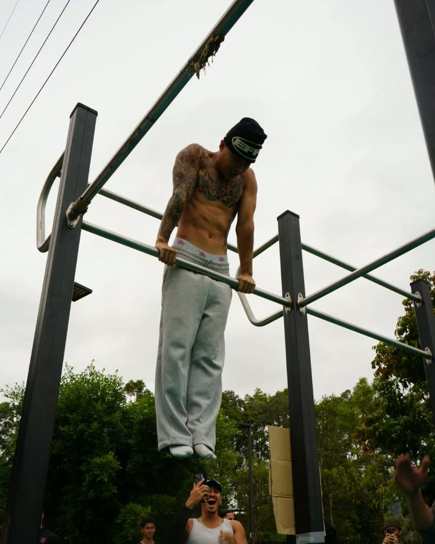 Athlete pressing out a muscle-up high on a pull-up bar